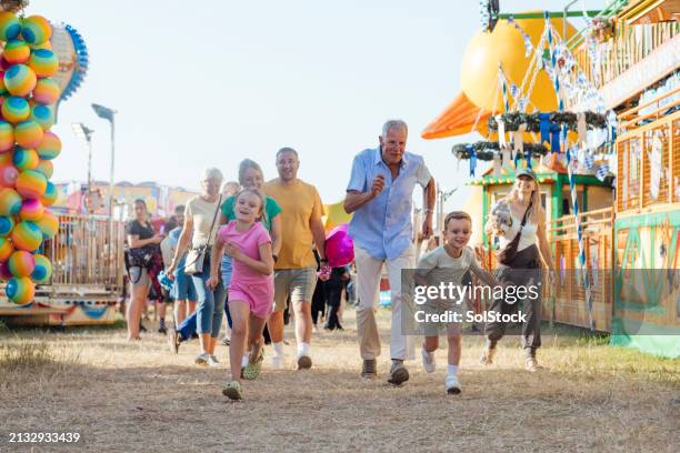 running towards the rides - family day stock pictures, royalty-free photos & images
