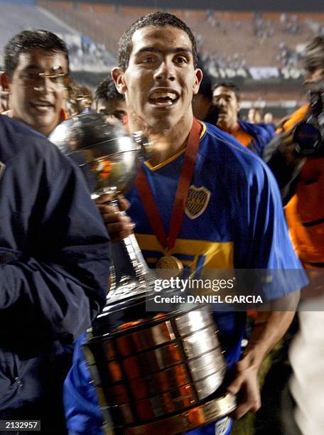 Carlos Tevez of Boca Juniors of Argentina, who was chosen the best player of the game, holds the trophy during the winning lap after deafeating the...