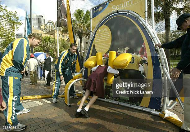 Australian Wallabies Matt Dunning and David Lyons show school children through some of the displays during the Australian Rugby Union's launch of the...