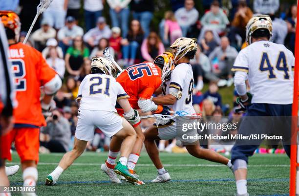 Sam English of Syracuse is checked by Carter Parlette and Shawn Lyght of Notre Dame during a game between Syracuse and Notre Dame at Arlotta Stadium...