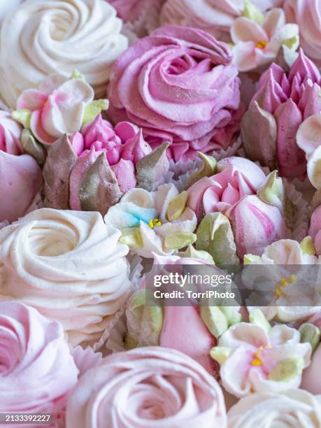 close-up pink and cream colored rosettes made from marshmallows, shaped like roses and tulips of different sizes stacked by the side of each other. zefir or zephyr flowers in the style of shabby chic - gelatin powder fotografías e imágenes de stock