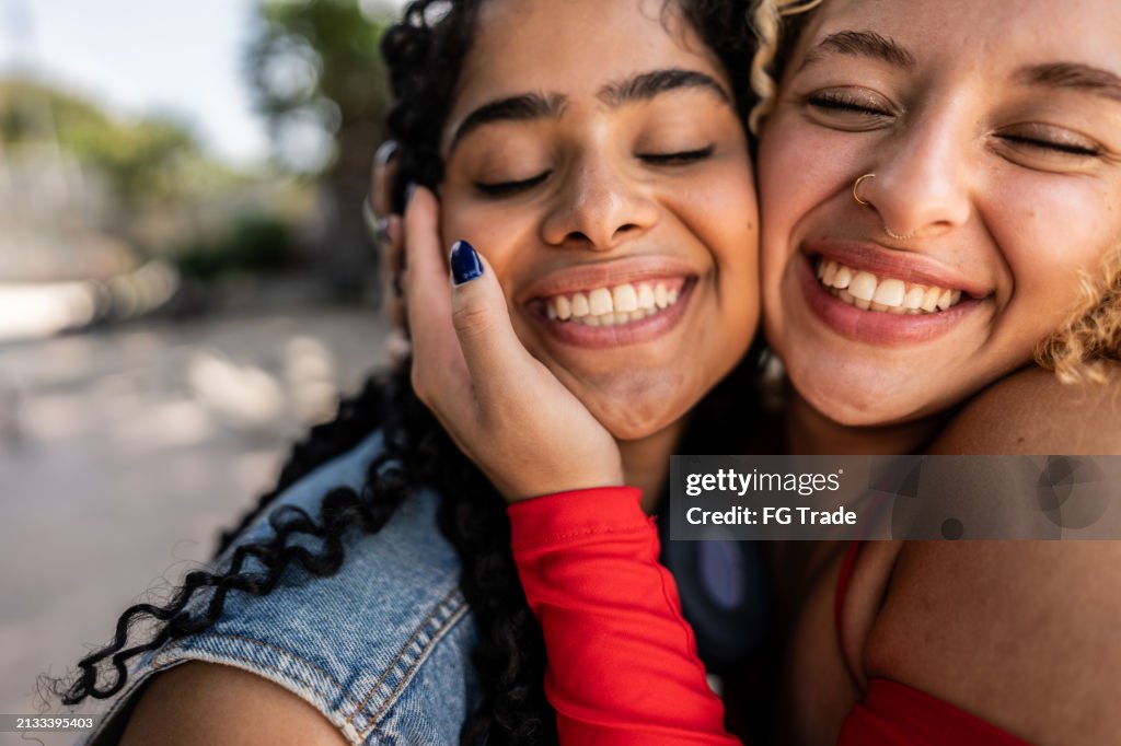 Young female friends embracing outdoors