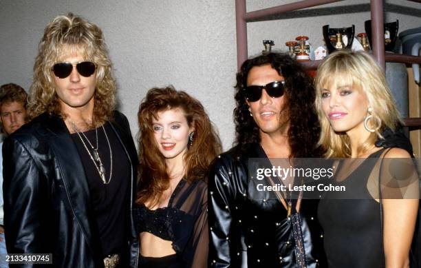 American musicians Robbin Crosby and Stephen Pearcy, of the American glam metal band Ratt, pose for a portrait with their girlfriends at an...