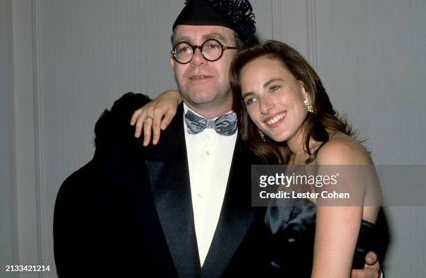 British singer Elton John and American actress Marlee Matlin pose for a portrait at an unspecified event in Los Angeles, California, circa 1990.