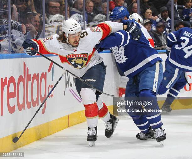 Ryan Lomberg of the Florida Panthers is held up by Mark Giordano of the Toronto Maple Leafs during the first period in an NHL game at Scotiabank...