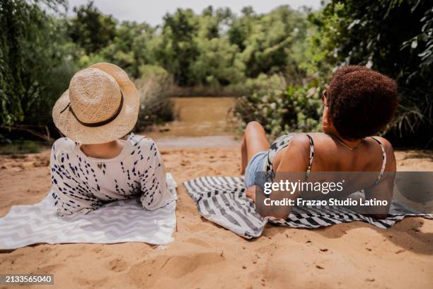 des amies allongées lors d’un voyage au bord de l’eau - lying on back photos et images de collection