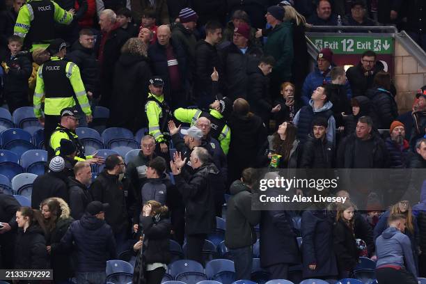 Police and stewards escort fans away from an area of the stand, due to an issue with the stadium roof during the Premier League match between Burnley...