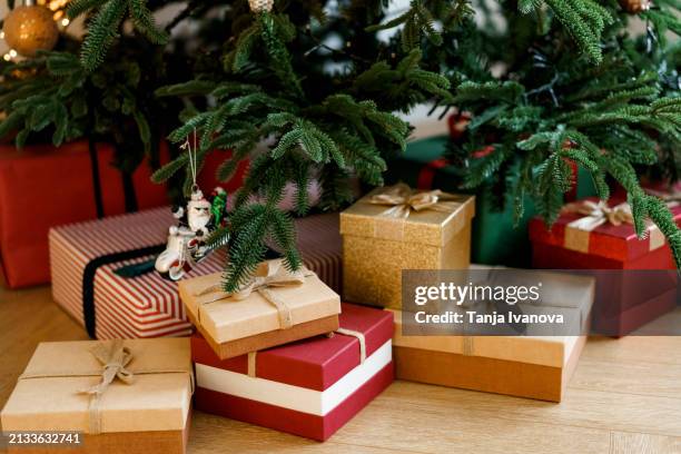 festive christmas gifts on background of a christmas tree. new year's present and christmas present. - gold sack stock pictures, royalty-free photos & images