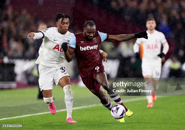 Destiny Udogie of Tottenham Hotspur battles for possession with Michail Antonio of West Ham United during the Premier League match between West Ham...