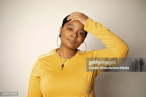 african-american woman with black headwrap looking forward while holding her head with left arm - head forward white background stock pictures, royalty-free photos & images