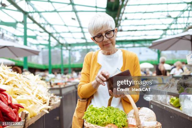 high food costs. senior woman holding wallet - wallet stock pictures, royalty-free photos & images