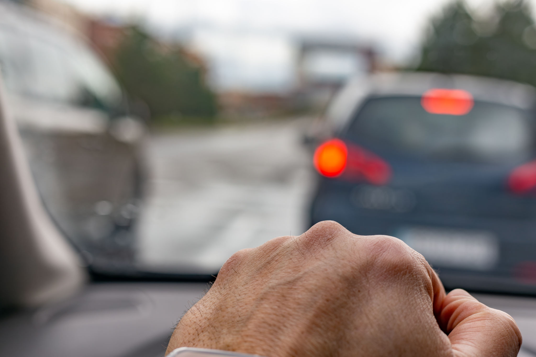 Main d’un homme sur le volant d’une voiture traversant la ville un jour de pluie. Main d’un homme sur le volant d’une voiture traversant la ville un jour de pluie.
