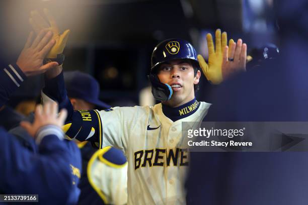 Christian Yelich of the Milwaukee Brewers is congratulated by teammates following a home run during the third inning of the home opener against the...