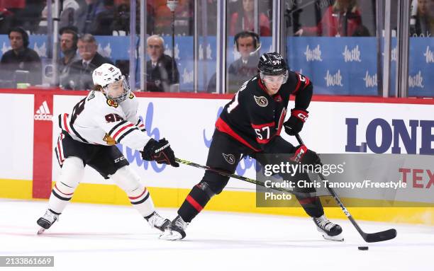 Connor Bedard of the Chicago Blackhawks battles for the puck with Shane Pinto of the Ottawa Senators at Canadian Tire Centre on March 28, 2024 in...
