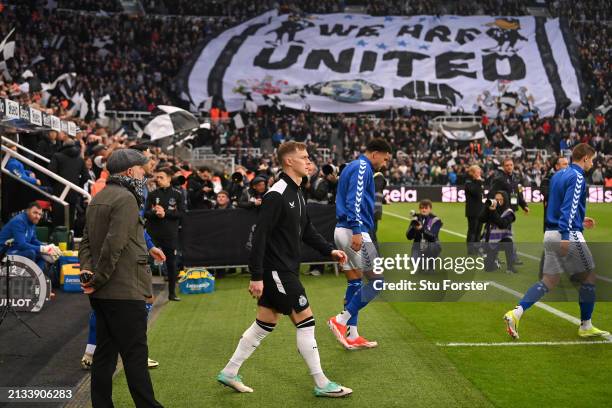 Newcastle player Emil Krafth walks onto the pitch as a flag reads 'We Are United' is seen in the Leazes End prior to the Premier League match between...