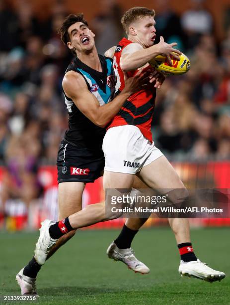 Ben Hobbs of the Bombers is tackled by Brandon Zerk-Thatcher of the Power during the 2024 AFL Round 04 match between the Port Adelaide Power and the...