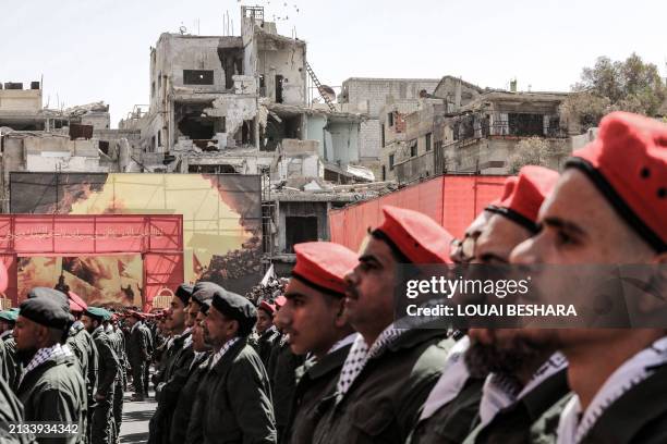 Palestinian members of a pro-Syrian government squad, take part in a military parade to mark the annual Quds Day commemorations, in the Yarmouk...