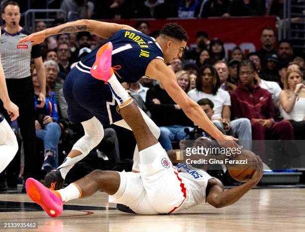 Clippers guard James Harden falls to the ground keeping the ball away from Denver Nuggets forward Michael Porter Jr. In the first half at Crypto.com...