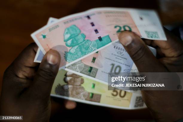 New Zimbabwean banknotes are displayed as Zimbabwe Reserve Bank Governer John Mushayavanhu presents his monetary policy statement during which he...