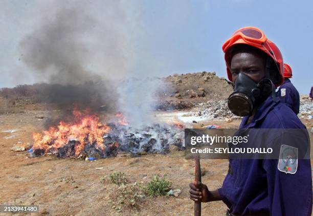 Senegalese fireman wears a gas mask as more than a tonne of confiscated drugs are burned 26 June 2001 in Dakar after the ministry of Internal Affairs...