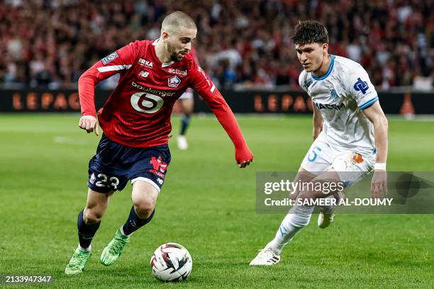 Lille's Kosovar midfielder Edon Zhegrova fights for the ball with Marseille's Italian Argentinian defender Leonardo Balerdi during the French L1...