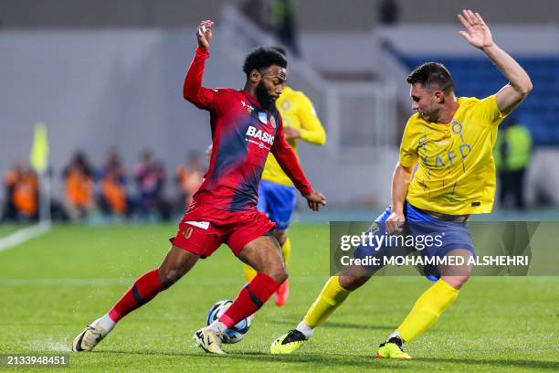 Damac's Cameroonian midfielder Georges-Kévin Nkoudou and Nassr's French defender Aymeric Laporte vie for the ball during the Saudi Pro League...