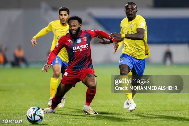 Nassr's Senegalese Forward Sadio Mane marks Damac's Cameroonian midfielder Georges-Kévin Nkoudou during the Saudi Pro League football match between...