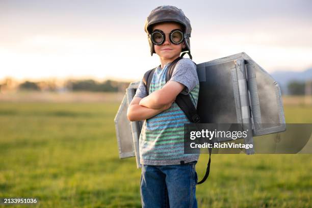 young boy with jetpack in grassy field - space jet pack stock pictures, royalty-free photos & images