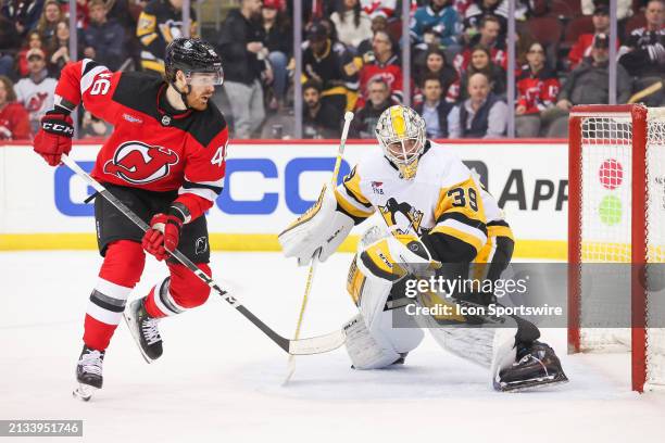 New Jersey Devils center Max Willman skates in front of Pittsburgh Penguins goaltender Alex Nedeljkovic during a game between the Pittsburgh Penguins...