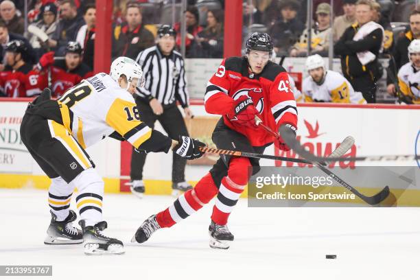 New Jersey Devils defenseman Luke Hughes skates by Pittsburgh Penguins right wing Jesse Puljujarvi during a game between the Pittsburgh Penguins and...