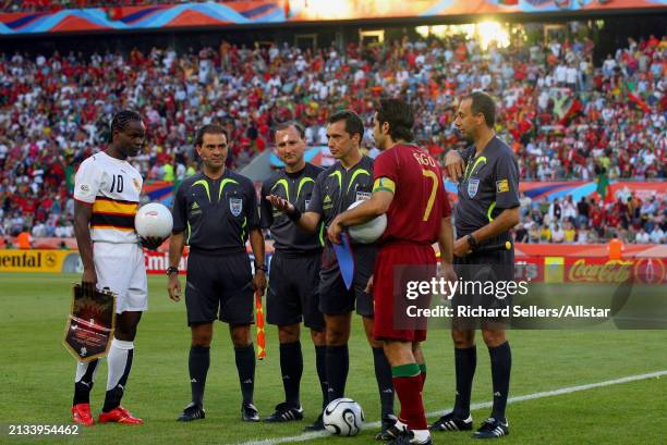 June 11: Fabrice Akwa of Angola and Luis Figo of Portugal watch Referee Jorge Larrionda toss coin before the FIFA World Cup Finals 2006 Group D match...