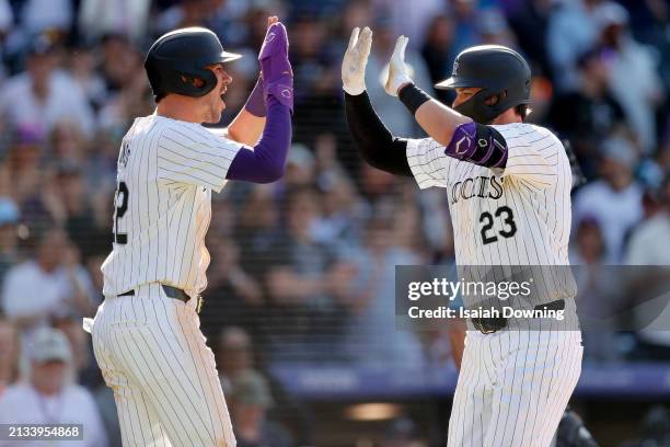 Nolan Jones and Kris Bryant of the Colorado Rockies celebrate after Bryant hit a two-run home run in the eighth inning during the game between the...