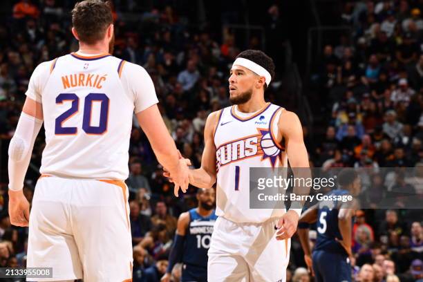 Devin Booker of the Phoenix Suns high fives Jusuf Nurkic during the game against the Minnesota Timberwolves on April 5, 2024 at Footprint Center in...
