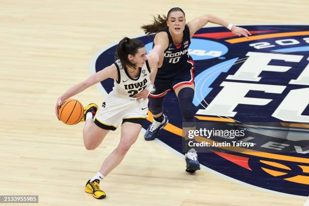 Nika Muhl of the UConn Huskies defends Caitlin Clark of the Iowa Hawkeyes during the NCAA Women's Basketball Tournament Final Four semifinal game at...