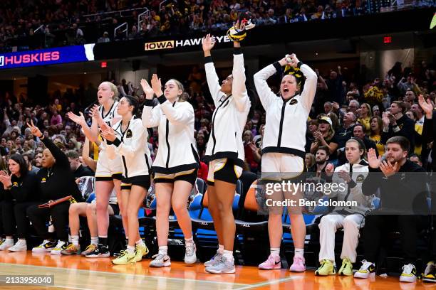 The Iowa Hawkeyes bench celebrates against the UConn Huskies during the NCAA Women's Basketball Tournament Final Four semifinal game at Rocket...