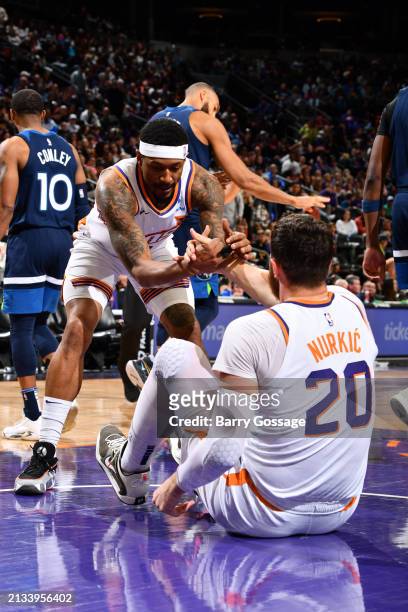 Bradley Beal of the Phoenix Suns helps up Jusuf Nurkic during the game against the Minnesota Timberwolves on April 5, 2024 at Footprint Center in...