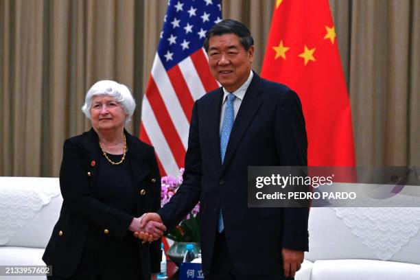 China's Vice Premier He Lifeng and US Treasury Secretary Janet Yellen shake hands before a meeting at the Guangdong Zhudao Guest House in the...