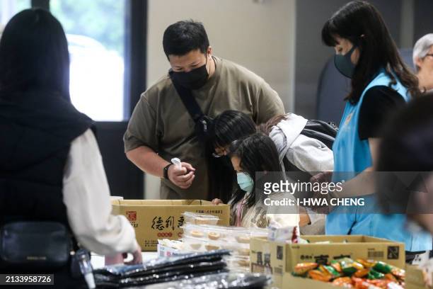 Local residents evacuated following an earthquake get food at a temporary centre at an elementary school, in Hualien on April 6, 2024. Ten people...