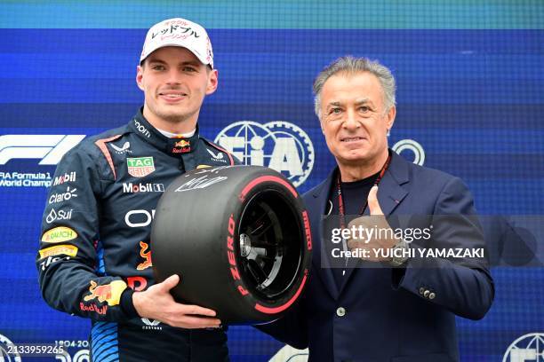 Pole position qualifier Red Bull Racing's Dutch driver Max Verstappen poses with former French F1 driver Jean Alesi after the qualifying session for...