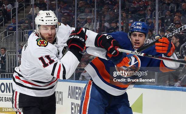 Taylor Raddysh of the Chicago Blackhawks and Alexander Romanov of the New York Islanders collide during the first period at UBS Arena on April 02,...