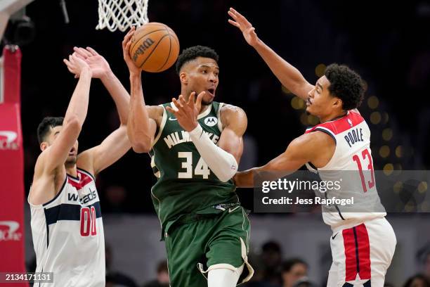 Giannis Antetokounmpo of the Milwaukee Bucks passes the ball as Tristan Vukcevic and Jordan Poole of the Washington Wizards defend during the second...