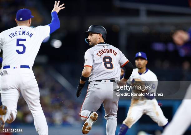Michael Conforto of the San Francisco Giants is caught trying to steal second base against the Los Angeles Dodgers in the third inning at Dodger...