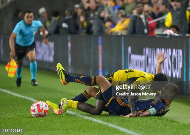 Yaw Yeboah of the Columbus Crew falls on top of Guido Pizarro of Tigres UANL while battling for the ball during the second half of the Concacaf...