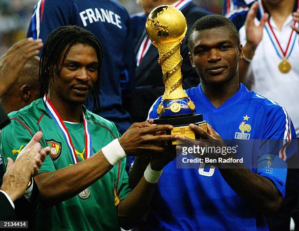 Rigobert Song of Cameroon and Marcel Desailly of France both hold the winning trophy after the FIFA Confederations Cup Final between France and...