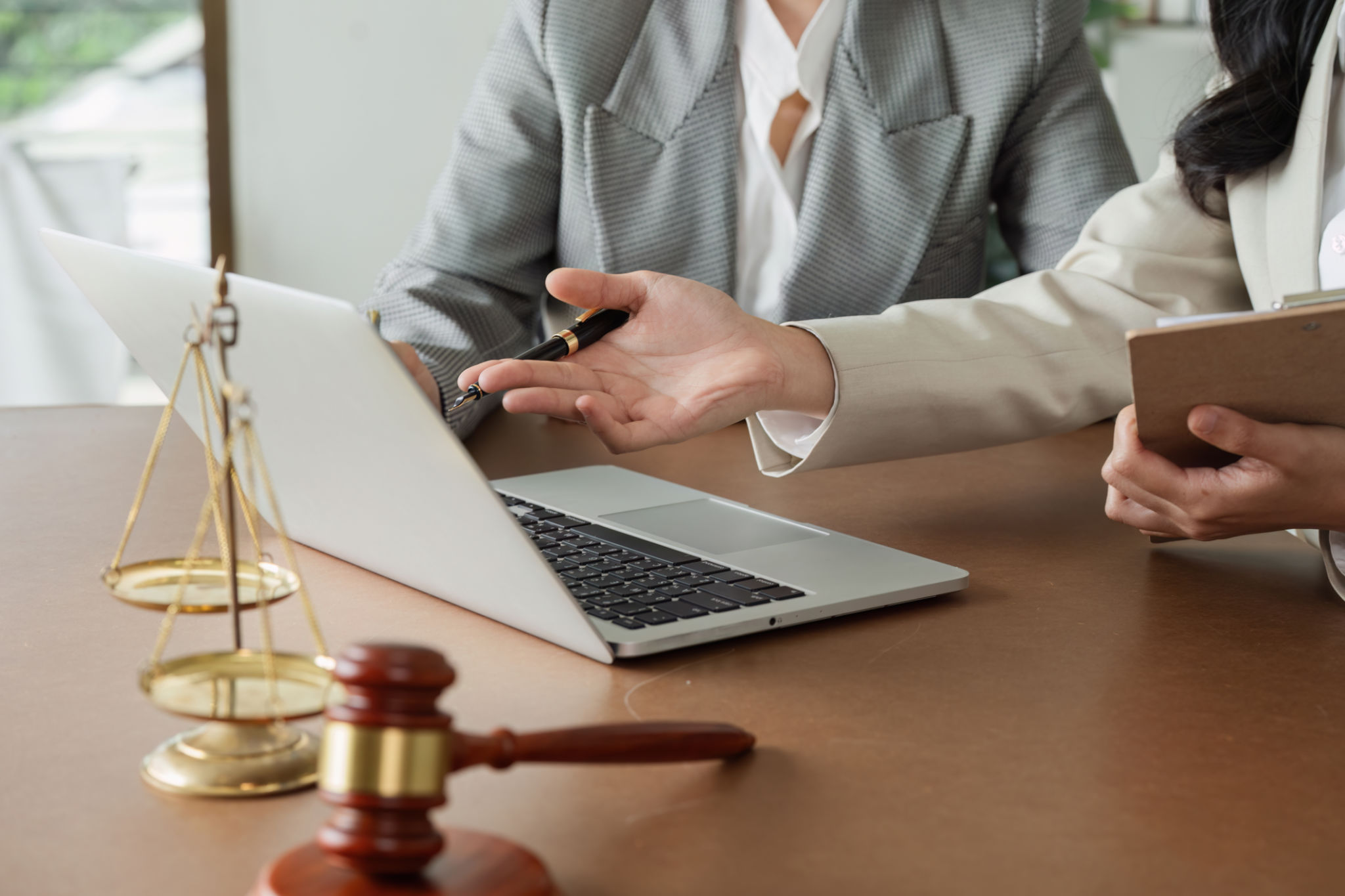 Lawyer and client discuss data on laptop, advise client on business matters on laptop Lawyer and client discuss data on laptop, advise client on business matters on laptop