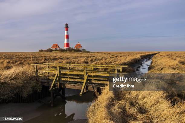 travel destination: bridge to westerhever lighthouse (schleswig-holstein, germany) - faro di westerhever foto e immagini stock