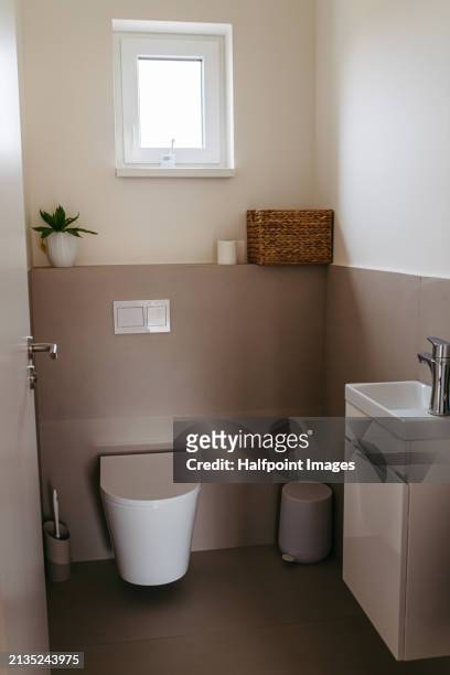 simple half bath, powder room in modern house. small bathroom with toilet and sink. - designer bath stock pictures, royalty-free photos & images