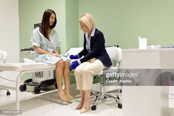 doctor checking reflexes of her patient - reflex hammer stock pictures, royalty-free photos & images