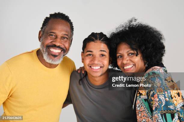 waist up shot of a beautiful family of middle aged hispanic latino black parents and a his son looking at the camera and smiling - afro caribbean people stock pictures, royalty-free photos & images