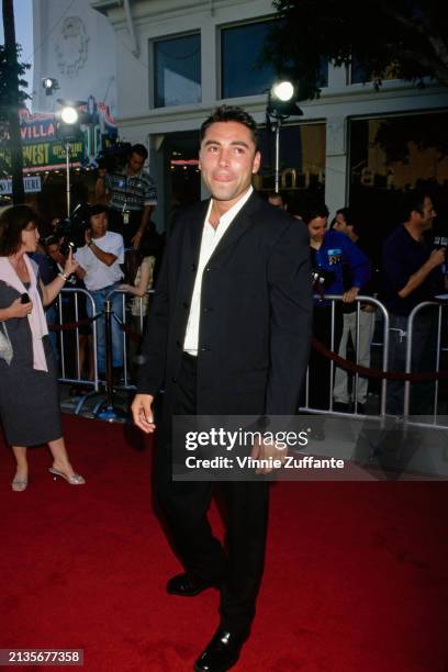 Mexican-American boxer Oscar De La Hoya, wearing a black suit over a white shirt, attends the Westwood premiere of 'Wild Wild West', at the Mann...